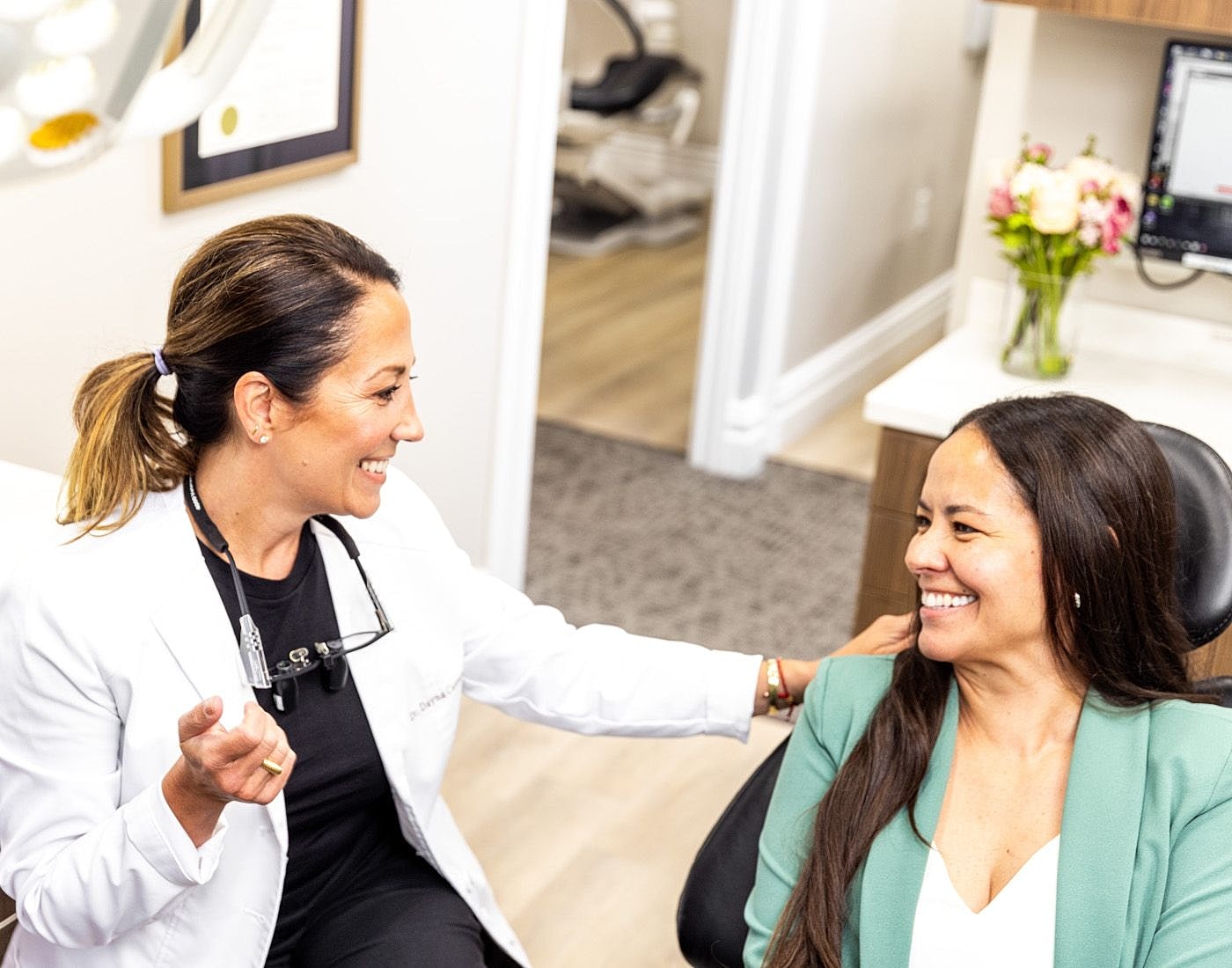 Dentist consulting with a patient, smiles exchanged.